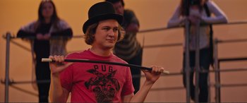 Movie still from “Love, Simon” (2018), directed by Greg Berlanti – A man in a top hat holding a cane; Medium shot, Over the shoulder angle