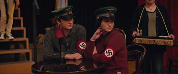 Movie still from “Love, Simon” (2018), directed by Greg Berlanti – A man and a woman in nazi garb sitting at a table; Medium shot, High angle