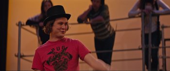 Movie still from “Love, Simon” (2018), directed by Greg Berlanti – A young man wearing a black hat and a red shirt; Medium shot, Over the shoulder angle