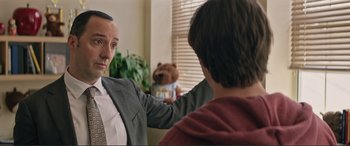 Movie still from “Love, Simon” (2018), directed by Greg Berlanti – A man in a suit and tie holding a teddy bear in front of another man; Close Up shot, Over the shoulder angle