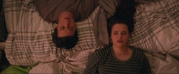 Movie still from “Love, Simon” (2018), directed by Greg Berlanti – A man and a woman laying in a bed together; Medium shot, Overhead angle
