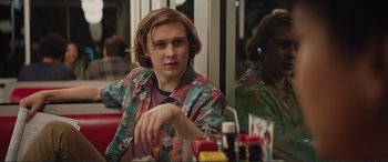 Movie still from “Love, Simon” (2018), directed by Greg Berlanti – A man sitting in front of a mirror at a table; Medium shot, Over the shoulder angle