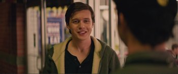 Movie still from “Love, Simon” (2018), directed by Greg Berlanti – A young man smiling while standing in front of a store window; Close Up shot, Over the shoulder angle
