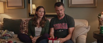 Movie still from “Love, Simon” (2018), directed by Greg Berlanti – A man and a woman sitting next to each other holding a present; Medium shot, Over the shoulder angle