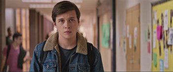 Movie still from “Love, Simon” (2018), directed by Greg Berlanti – A young man in a denim jacket standing in a hallway; Close Up shot, Over the shoulder angle