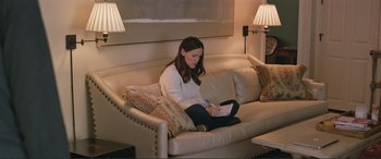 Movie still from “Love, Simon” (2018), directed by Greg Berlanti – A woman sitting on top of a white leather couch; Medium shot, High angle