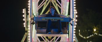 Movie still from “Love, Simon” (2018), directed by Greg Berlanti – A man sitting in a ferris wheel at night; Wide shot, Low angle