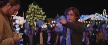 Movie still from “Love, Simon” (2018), directed by Greg Berlanti – A young man pointing at something while standing in front of a crowd of onlookers; Medium shot, Over the shoulder angle