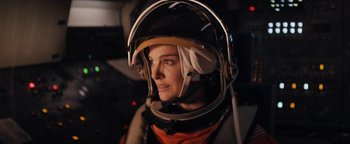 Movie still from “Lucy in the Sky” (2019), directed by Noah Hawley – A woman wearing a helmet is looking into the distance; Close Up shot, Overhead angle