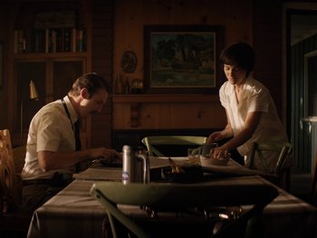 Movie still from “Lucy in the Sky” (2019), directed by Noah Hawley – A man and a woman sitting at a dinner table; Medium shot, Low angle