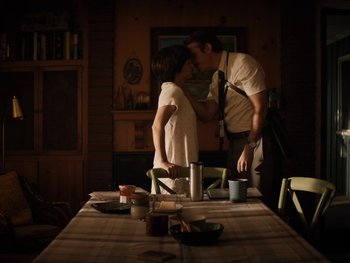 Movie still from “Lucy in the Sky” (2019), directed by Noah Hawley – A man and a woman standing in front of a dining room table; Medium shot, Low angle