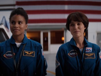 Movie still from “Lucy in the Sky” (2019), directed by Noah Hawley – Two women in blue space suits standing next to each other; Medium shot, Over the shoulder angle