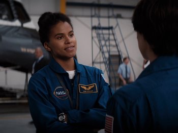 Movie still from “Lucy in the Sky” (2019), directed by Noah Hawley – A woman in a nasa uniform talking to a man in a blue suit; Medium shot, Over the shoulder angle