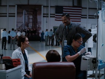 Movie still from “Lucy in the Sky” (2019), directed by Noah Hawley – A group of doctors and nurses in an industrial setting; Wide shot, Over the shoulder angle
