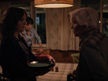 Movie still from “Lucy in the Sky” (2019), directed by Noah Hawley – Two women and a man are holding a tray; Medium shot, Over the shoulder angle