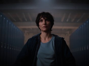 Movie still from “Lucy in the Sky” (2019), directed by Noah Hawley – A person standing in a dark room with a light on; Close Up shot, Low angle
