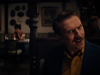 Movie still from “Lucy in the Sky” (2019), directed by Noah Hawley – A man in a yellow and blue suit is looking at the camera; Close Up shot, Low angle