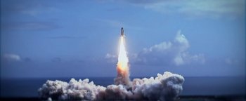 Movie still from “Lucy in the Sky” (2019), directed by Noah Hawley – A rocket is flying through the air with smoke coming out of it; Extreme Wide shot, Low angle