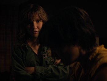 Movie still from “Lucy in the Sky” (2019), directed by Noah Hawley – A young woman standing next to a young man in a dark room; Medium shot, Over the shoulder angle