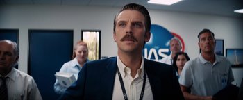 Movie still from “Lucy in the Sky” (2019), directed by Noah Hawley – A man with a mustache in a room; Close Up shot, Low angle
