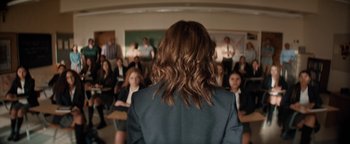 Movie still from “Lucy in the Sky” (2019), directed by Noah Hawley – A group of people sitting in a room with a woman in the foreground; Medium shot, Over the shoulder angle