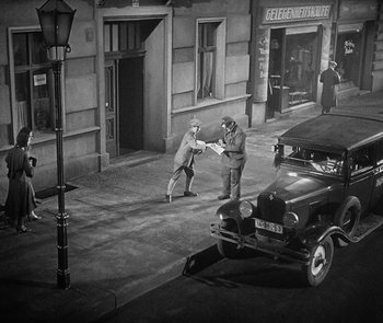 Movie still from “M” (1931), directed by Fritz Lang – Two men are playing a game on the street; Extreme Wide shot, High angle
