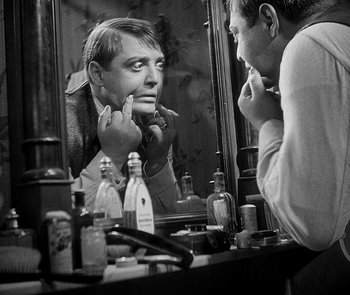 Movie still from “M” (1931), directed by Fritz Lang – A black and white photo of a man looking at himself in the mirror; Close Up shot, Over the shoulder angle