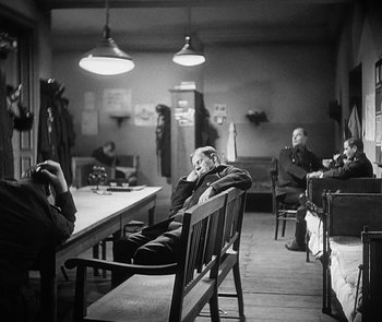 Movie still from “M” (1931), directed by Fritz Lang – A group of people sitting around a table; Wide shot, High angle