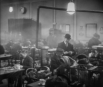 Movie still from “M” (1931), directed by Fritz Lang – A group of people sitting at tables in a room; Wide shot, High angle