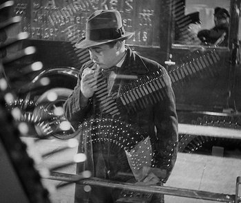 Movie still from “M” (1931), directed by Fritz Lang – A black and white photo of a man holding a guitar; Medium shot, High angle