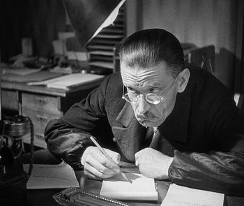 Movie still from “M” (1931), directed by Fritz Lang – An older man writing on a piece of paper; Close Up shot, Low angle