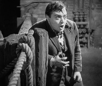 Movie still from “M” (1931), directed by Fritz Lang – An old photo of a man with a surprised look on his face; Medium shot, High angle