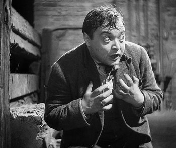 Movie still from “M” (1931), directed by Fritz Lang – An old photo of a man holding something in his mouth; Medium shot, High angle