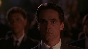 Movie still from “M. Butterfly” (1993), directed by David Cronenberg – A man in a suit and tie; Close Up shot, Over the shoulder angle