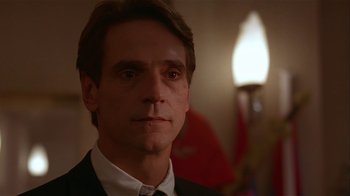 Movie still from “M. Butterfly” (1993), directed by David Cronenberg – A person wearing a suit and tie; Close Up shot, Low angle