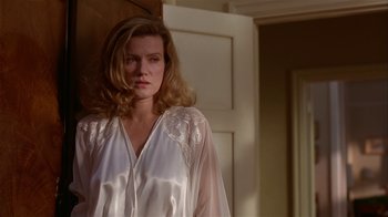 Movie still from “M. Butterfly” (1993), directed by David Cronenberg – A woman standing in front of a door wearing a white robe; Medium shot, Low angle