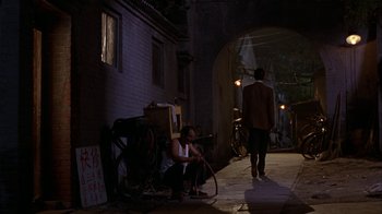 Movie still from “M. Butterfly” (1993), directed by David Cronenberg – A man and a woman sitting on the side of the street; Wide shot, Over the shoulder angle