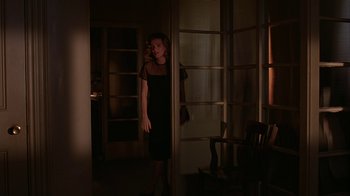 Movie still from “M. Butterfly” (1993), directed by David Cronenberg – A woman in a black dress standing in front of a window; Wide shot, Over the shoulder angle