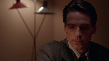 Movie still from “M. Butterfly” (1993), directed by David Cronenberg – A person wearing a suit and tie; Close Up shot, Over the shoulder angle