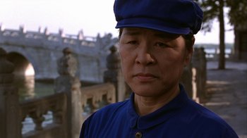 Movie still from “M. Butterfly” (1993), directed by David Cronenberg – An older man wearing a blue hat and a blue shirt; Close Up shot, Low angle