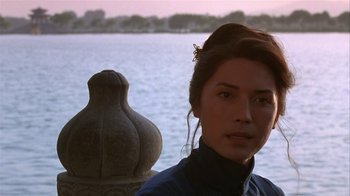 Movie still from “M. Butterfly” (1993), directed by David Cronenberg – A woman standing in front of a body of water; Close Up shot, Over the shoulder angle