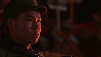 Movie still from “M. Butterfly” (1993), directed by David Cronenberg – A man wearing a hat is looking to his left; Close Up shot, Low angle