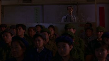 Movie still from “M. Butterfly” (1993), directed by David Cronenberg – A group of people standing in front of a wall; Medium shot, Over the shoulder angle