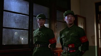 Movie still from “M. Butterfly” (1993), directed by David Cronenberg – A couple of men standing next to each other; Medium shot, Low angle