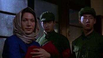 Movie still from “M. Butterfly” (1993), directed by David Cronenberg – A group of men and women standing next to each other; Close Up shot, Over the shoulder angle