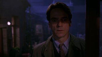 Movie still from “M. Butterfly” (1993), directed by David Cronenberg – A person wearing a suit and tie; Close Up shot, Low angle