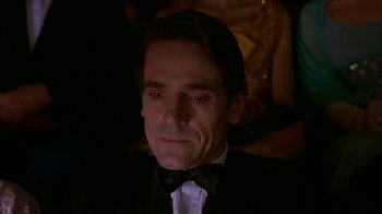 Movie still from “M. Butterfly” (1993), directed by David Cronenberg – A person wearing a suit and bow tie; Close Up shot, Low angle