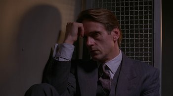 Movie still from “M. Butterfly” (1993), directed by David Cronenberg – A person wearing a suit and tie; Close Up shot, Low angle