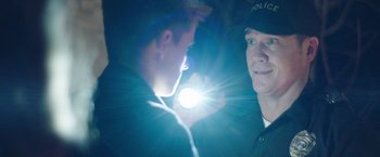 Movie still from “Ma” (2019), directed by Tate Taylor – Two police officers standing next to each other in a dark room; Close Up shot, Over the shoulder angle