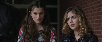 Movie still from “Ma” (2019), directed by Tate Taylor – Two young women standing next to each other in front of a brick wall; Close Up shot, Over the shoulder angle